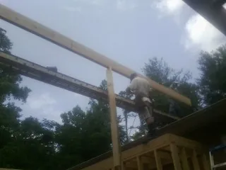 Carpenter setting a ridge beam over a new addition frame — Ice Dam Removal by Roofing Brothers in Cook Springs