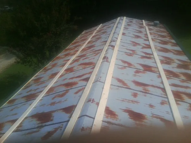 Rusted metal roof panels with new wood purlins before replacement — Storm Damage Roof Repair in Cook Springs by Roofing Brothers