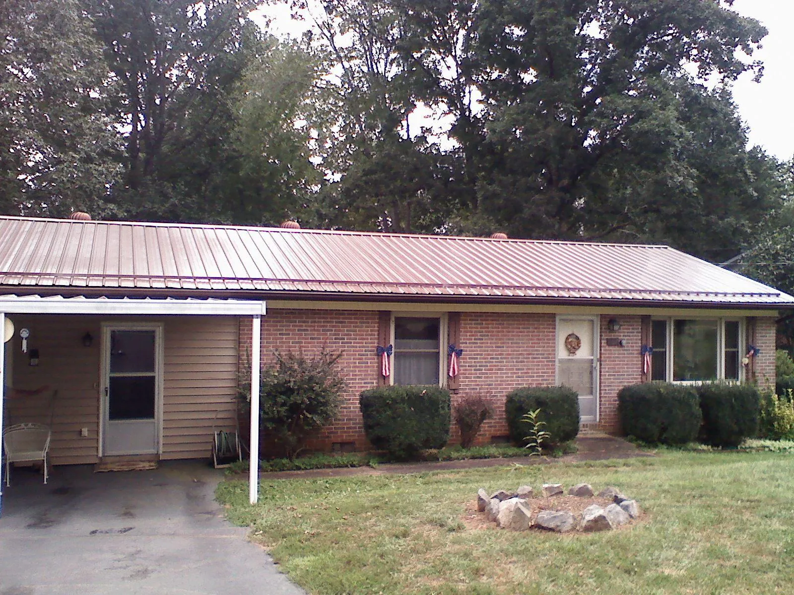 Bronze metal roof and carport on a brick ranch home — Roof Repair work by our crew in Cook Springs